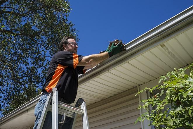 replacing a rusted gutter with a new one in Harveysburg, OH